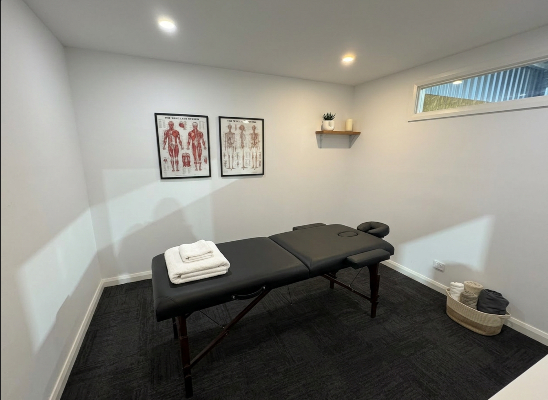Actual Rejuvenate Recovery Room studio setup with a black massage table